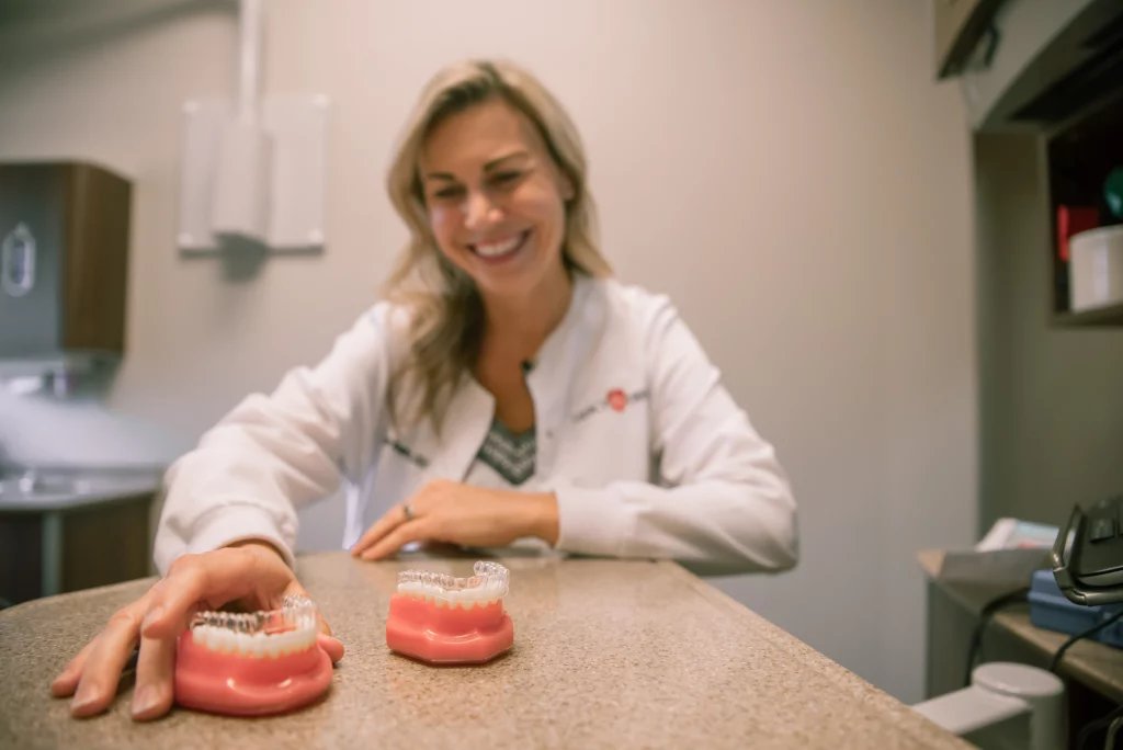 Our Burleson dentist, DR. HEATHER MAGERS, smiling and showcasing how Clear Aligners work at Legacy Dental.